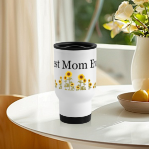 Custom travel mug with a sunflower “Best Mom Ever” print, displayed on a glass table with flowers and fruit in the background.