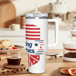 40oz Memorial Day handle tumbler with "Honoring Our Heroes" print, featuring a distressed American flag design, shown in a kitchen setting.