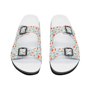 Pair of two-strap cork slide sandals with light blue straps printed with repeating orange soccer ball pattern (2026 World Cup theme), adjustable metal buckles, white footbed, black rubber outsole. Front view.