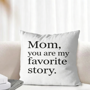 White linen throw pillow cover on a light-colored sofa, printed with the text “Mom, you are my favorite story.” in black serif font, creating a cozy, minimalist Mother’s Day home decor look.