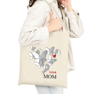 Custom canvas tote bag with “Love MOM” butterfly print, carried by a person wearing a light jacket.