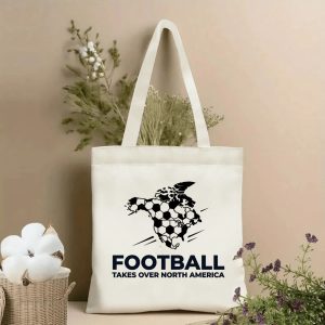 2026 World Cup North America Map Tote Bag, dynamic "Football Takes Over North America" graphic with North America map shaped like a soccer ball, beige polyester tote bag displayed with cotton branches, minimalist fan accessory