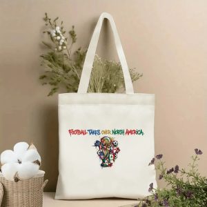 Beige canvas tote bag styled with dried botanicals, featuring multicolored "Football Takes Over North America" graffiti text and a vibrant FIFA World Cup trophy print with Canada, USA, Mexico flags, 2026 North America World Cup fan accessory