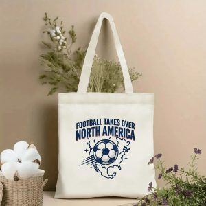 Front view of beige canvas tote with "Football Takes Over North America" vintage slogan and retro soccer ball + North America map print, styled with dried botanicals, 2026 World Cup fan accessory.