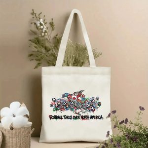 Front view of beige canvas tote with "Football Takes Over North America" graffiti text and vibrant North America map soccer print, styled with dried botanicals, 2026 World Cup fan accessory.