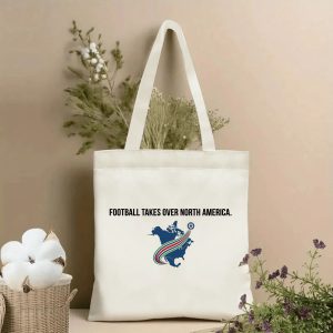 Front view of beige canvas tote with "Football Takes Over North America" text and North America map with tri-color speed stripe & soccer ball print, styled with dried botanicals, 2026 World Cup fan accessory.