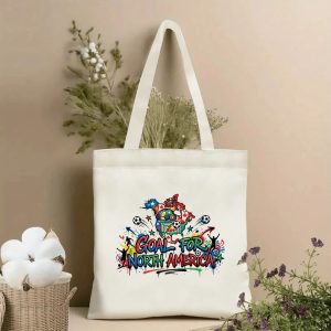 Front view of a beige canvas tote bag with a vibrant 2026 World Cup design. Features a bold graffiti-style North America map, "GOAL FOR NORTH AMERICA" lettering, colorful soccer balls, cheering fans, a goal net, and dynamic street-art splatters, styled with cotton stems and dried botanicals.