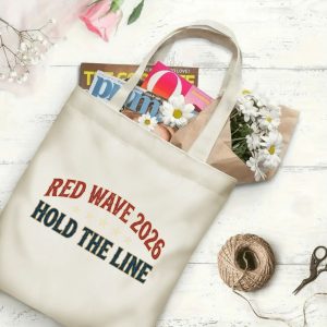 Natural canvas tote bag with "RED WAVE 2026 HOLD THE LINE" print, being carried over the shoulder by a person, showing rolled posters inside.