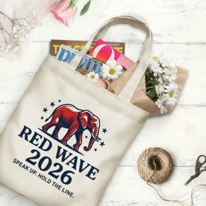 Natural canvas tote bag with "Red Wave 2026" graphic print, shown open with magazines and flowers inside. The design includes a Republican elephant, "RED WAVE 2026" text, and "SPEAK UP. HOLD THE LINE." slogan.