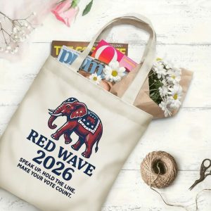 Natural canvas tote bag with a "Red Wave 2026" graphic print, shown open with magazines and flowers inside, placed on a white wooden background. The design includes a Republican elephant and "Make Your Vote Count" text.