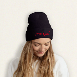 Graduation "Proud Grad" beanie worn on a model, showing the classic black knit design with red embroidered text.