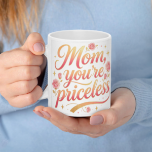 A white 11oz ceramic coffee mug held in hands, featuring "Mom, you're priceless" in pink-to-gold gradient cursive text surrounded by pink roses and sparkles.