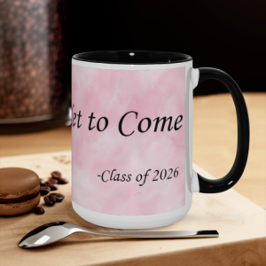 Class of 2026 "The Best is Yet to Come" mug on a kitchen counter, with pink watercolor background print and black handle.