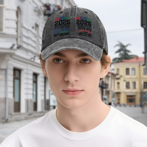 Young man wearing dark gray vintage washed adjustable dad hat, front dual‑side multi‑color stacked typography print of 2026 North America United soccer slogans, street‑style outdoor lifestyle shot, unisex World Cup sports baseball cap