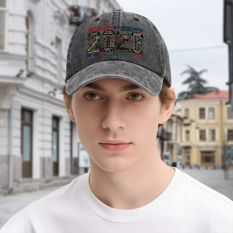 Young man wearing dark gray vintage washed adjustable dad hat, front large‑number multi‑color word‑cloud “2026 United North America United It’s Called Soccer” typography print, street‑style outdoor lifestyle shot, unisex 2026 World Cup sports baseball cap