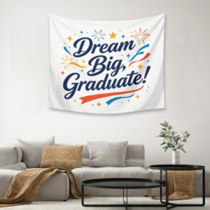 Graduation tapestry wall decor with "Dream Big, Graduate!" text, stars, and fireworks print, hung in a living room as a festive backdrop.