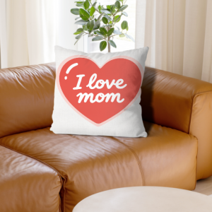 White linen throw pillow cover with "I love mom" print, white cursive text inside a coral heart with pink outline, home decor for Mother’s Day
