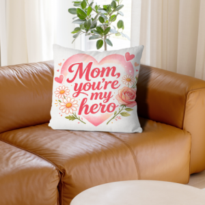 White linen throw pillow cover with "Mom, you're my hero" print, red cursive lettering inside a pink watercolor heart with daisy and rose accents, home decor for Mother’s Day