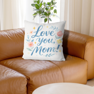 White linen throw pillow cover with "Love you, Mom!" print, watercolor blue cursive lettering with pastel floral and star accents, home decor for Mother’s Day