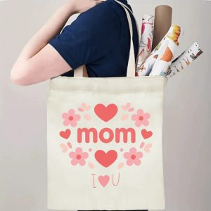 A person carrying the "mom" floral print canvas tote bag over their shoulder, showing its comfortable straps and roomy design with rolled papers inside.