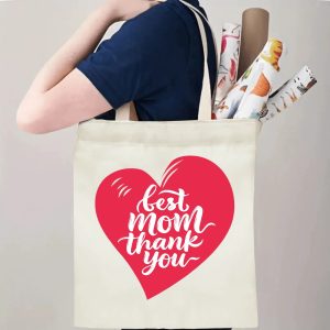 A person carrying the "best mom thank you" print canvas tote bag over their shoulder, showing its comfortable straps and roomy design with rolled papers inside.