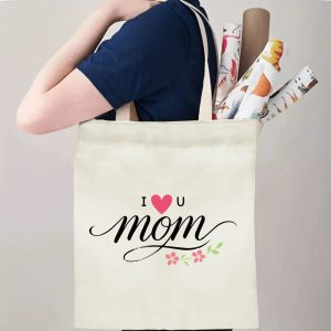 A person carrying the "I ❤️ U mom" print canvas tote bag over their shoulder, showing its comfortable straps and roomy design with rolled papers inside.