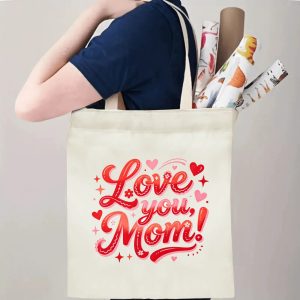 A person carrying the "Love you, Mom!" print canvas tote bag over their shoulder, showing its comfortable straps and roomy design with rolled papers inside.