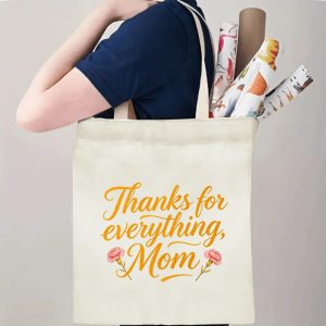 A person carrying the "Thanks for everything, Mom" print canvas tote bag over their shoulder, showing its comfortable straps and roomy design with rolled papers inside.