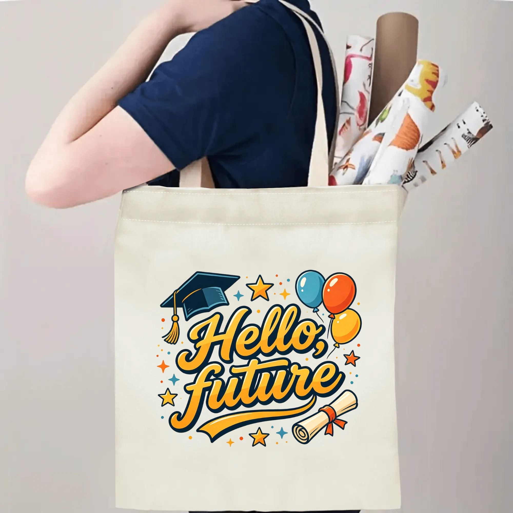 Person carrying natural canvas graduation tote bag with "Hello, future" celebratory print, graduation cap and balloon graphics, casual milestone‑celebrating reusable gift bag