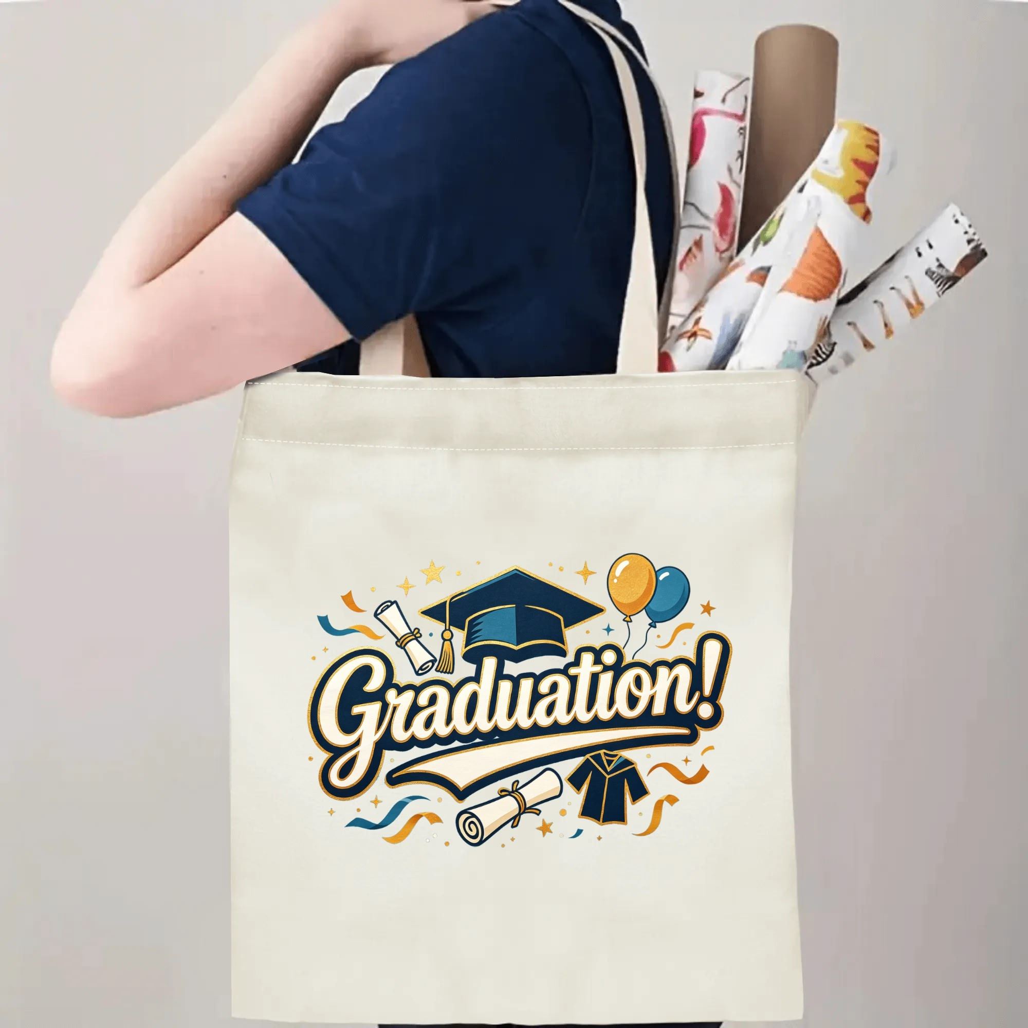 Person carrying natural canvas graduation tote bag with classic celebratory "Graduation!" print, graduation cap and diploma graphics, casual milestone‑celebrating reusable gift bag