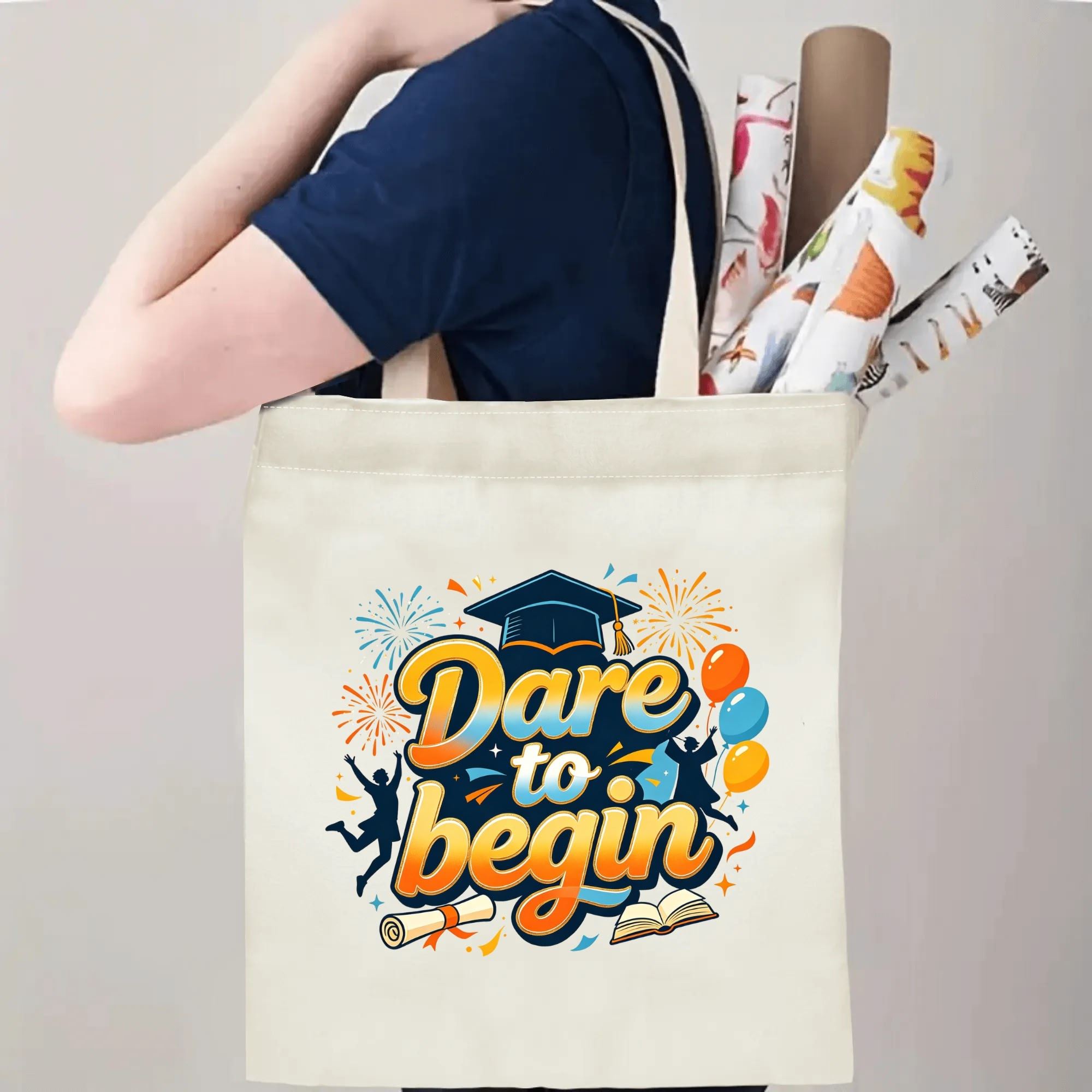 Person carrying natural canvas graduation tote bag with upbeat "Dare to begin" gradient‑colored print, graduation cap and joyful graduate graphics, casual milestone‑celebrating reusable gift bag