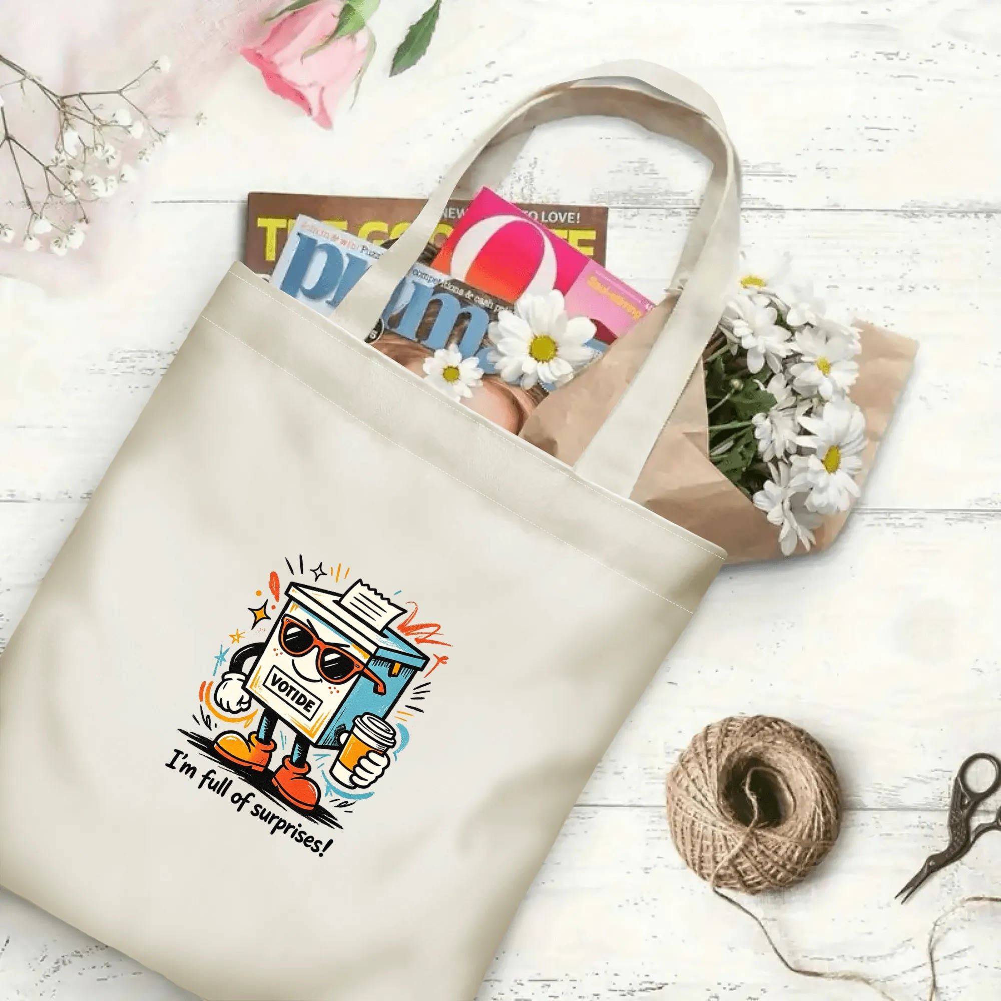 Flat‑lay shot of natural canvas political novelty tote bag with trendy anthropomorphic ballot box graphic, sunglasses and coffee cup details, playful election‑themed quote, decorated with daisies, ideal casual daily‑use bag for voters