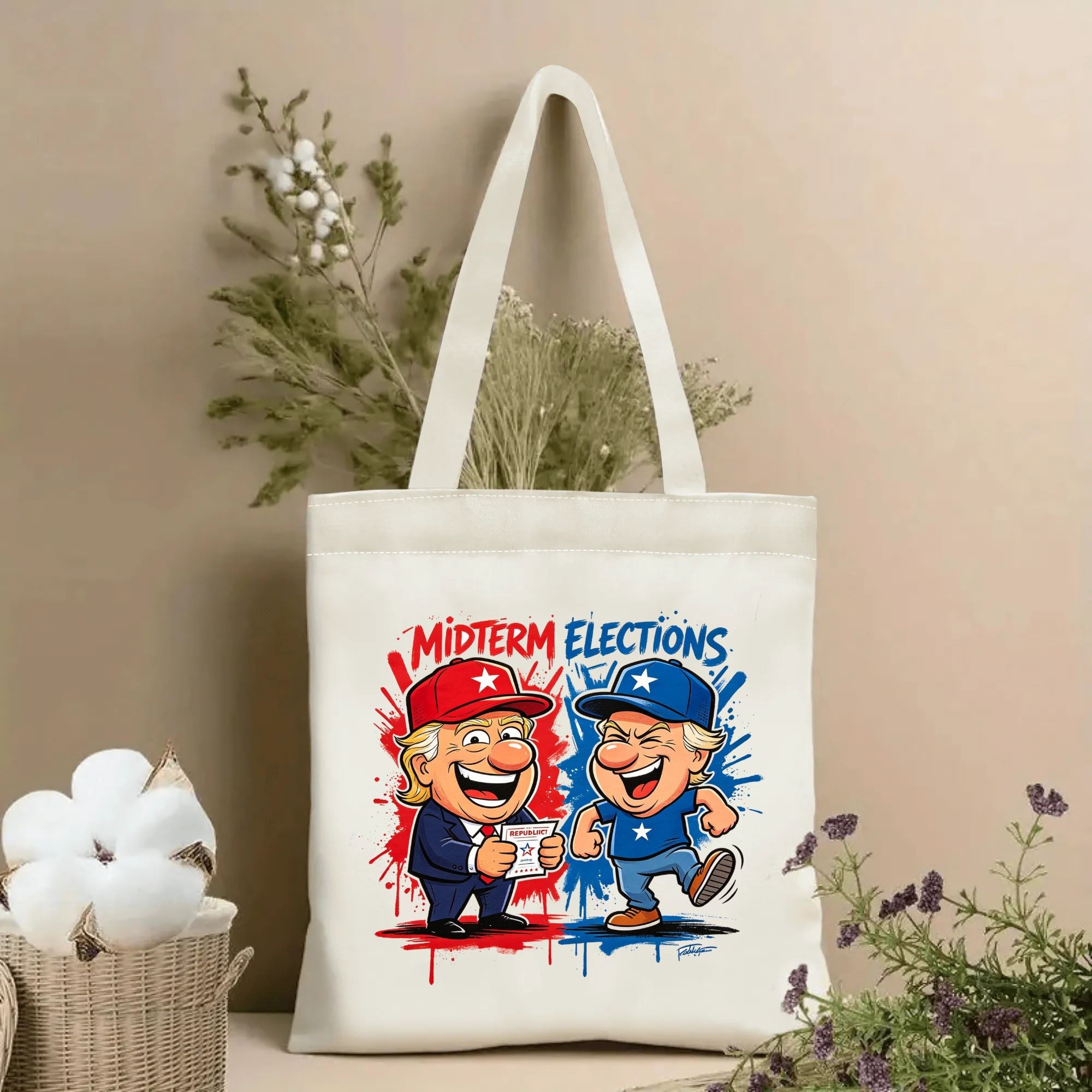 Natural canvas 2026 US mid‑term election themed tote bag featuring two playful cartoon political character illustrations in red and blue party colors, with bold "MIDTERM ELECTIONS" lettering and splatter paint background, styled with dried flowers for voting‑season gift display