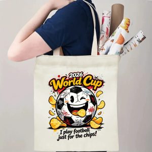 Person carrying natural canvas 2026 World Cup fan‑gift tote bag with playful rebellious street‑art soccer‑chips mascot design, reusable sports accessory for tournament viewing, fan events or everyday errands