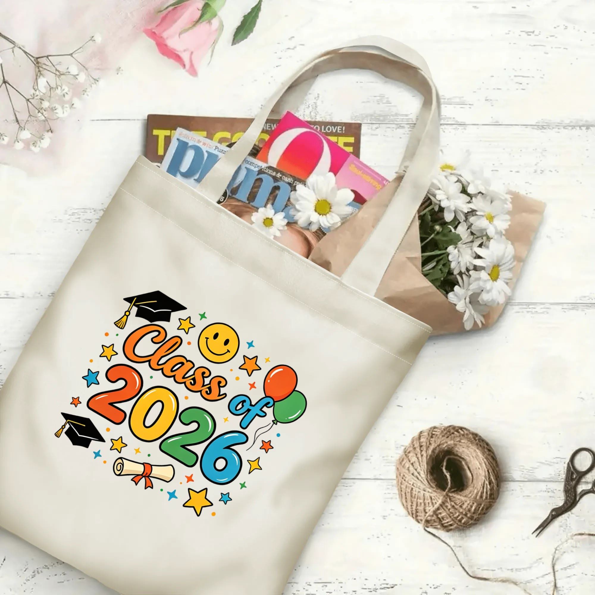 "Class of 2026" canvas tote bag in use, holding books, flowers, and other items, with colorful graduation graphics