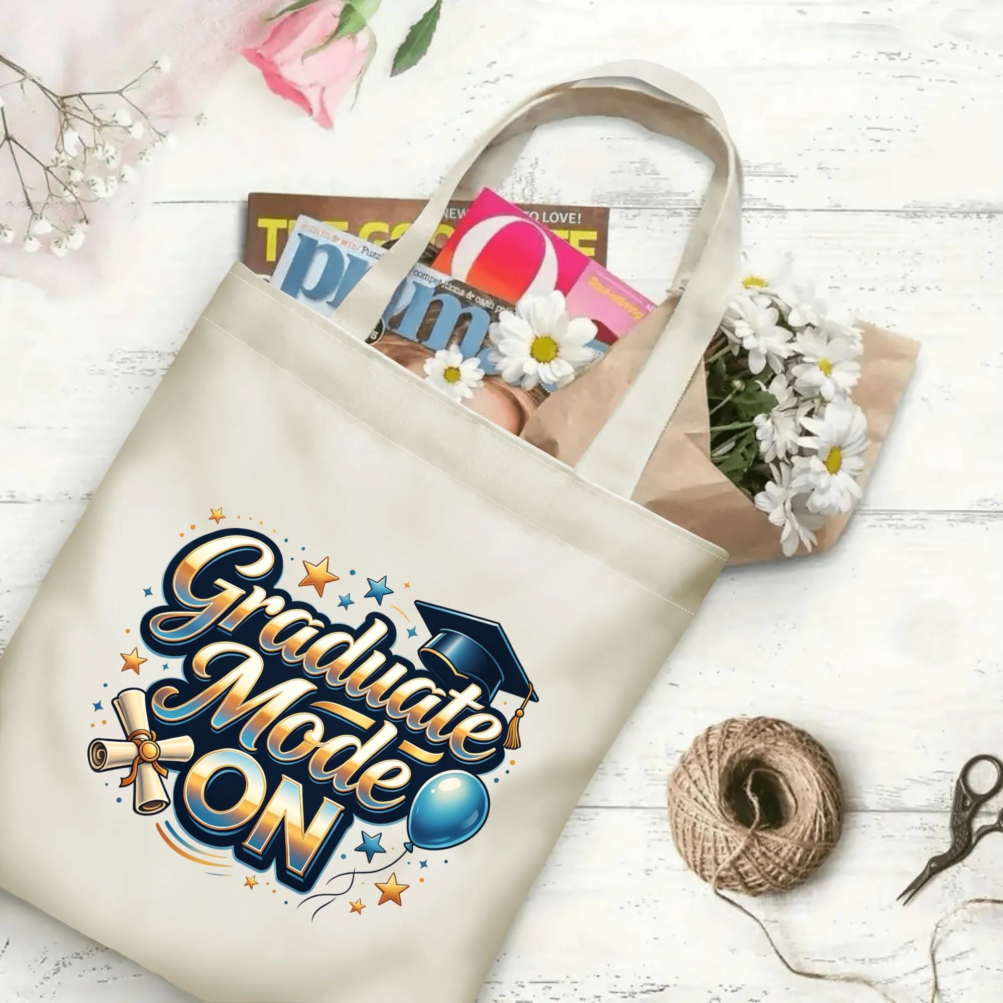 "Graduate Mode ON" canvas tote bag in use, holding books, flowers, and gifts, with festive graduation graphics