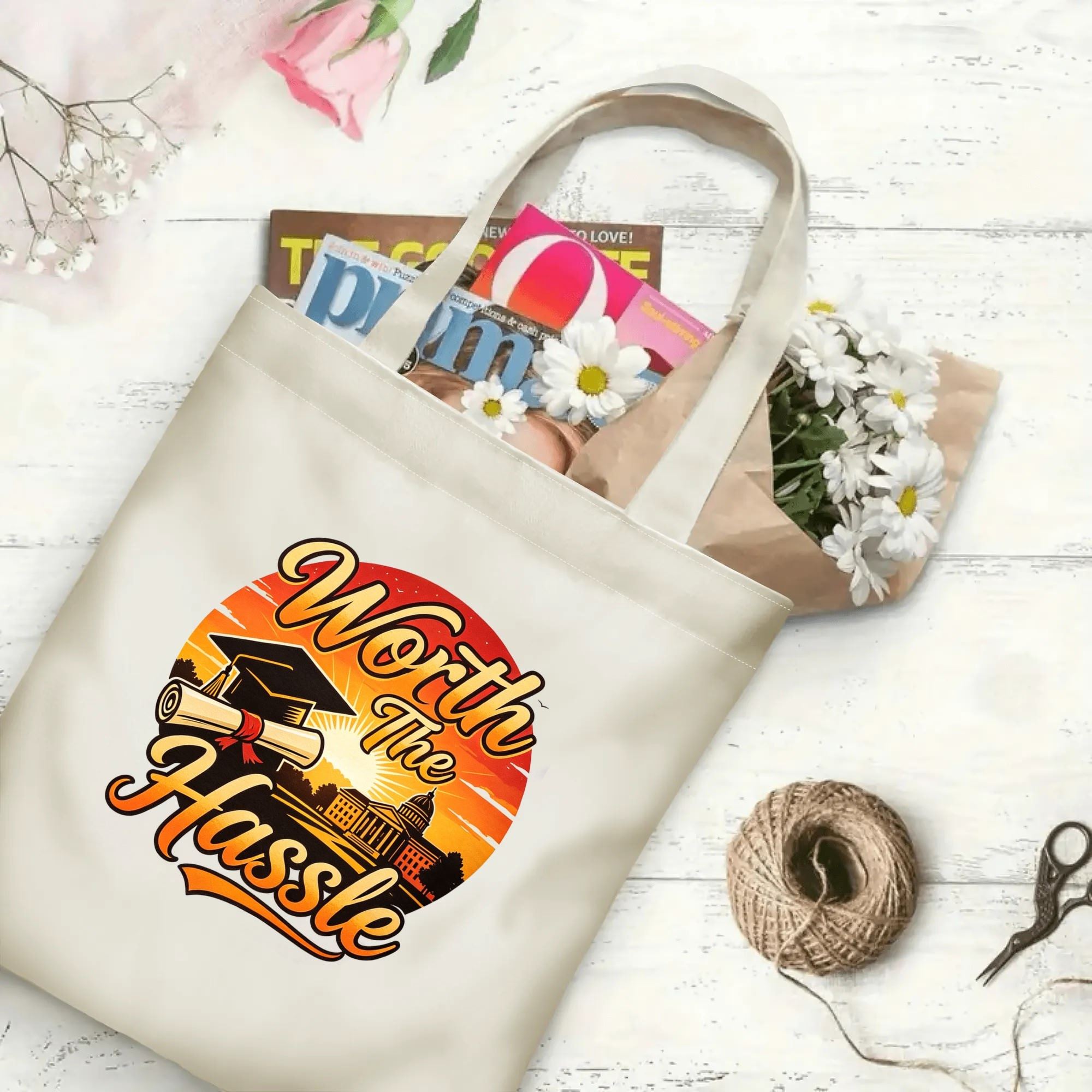 “Worth The Hassle” sunset‑themed canvas tote bag in use, holding books, flowers, and gifts.