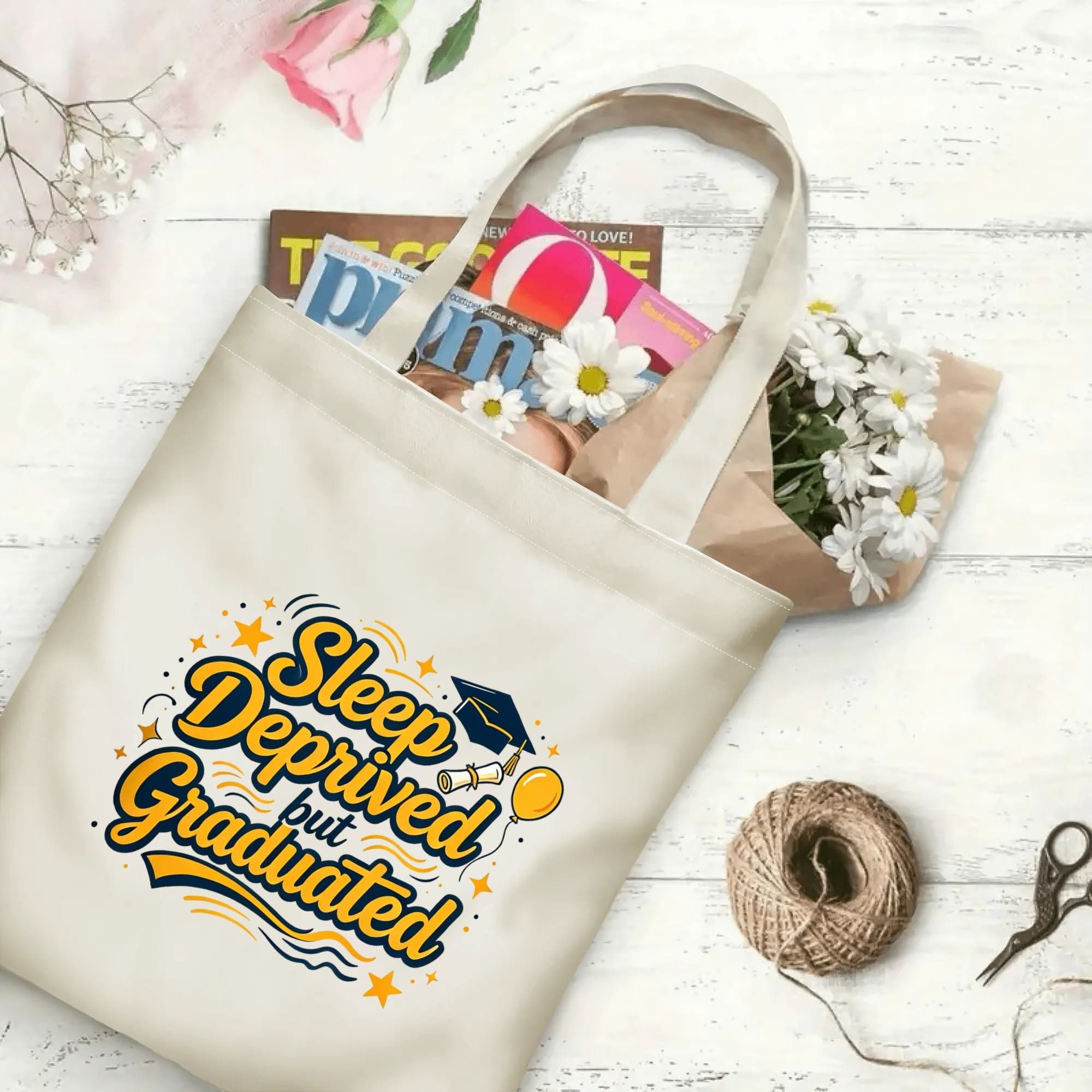 “Sleep Deprived but Graduated” playful‑style canvas tote bag in use, holding books, flowers, and gifts.