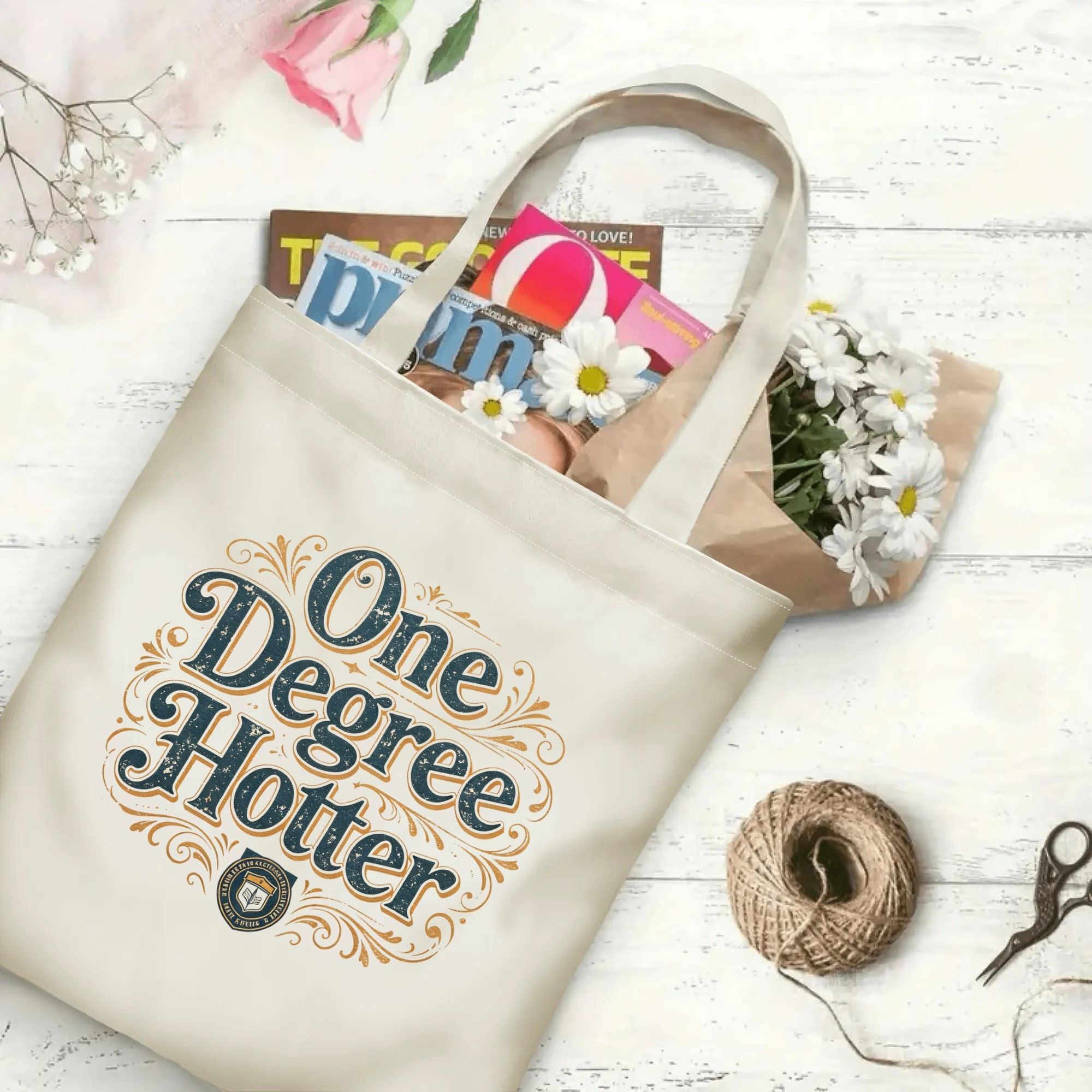 “One Degree Hotter” retro-style canvas tote bag in use, holding books, flowers, and gifts.