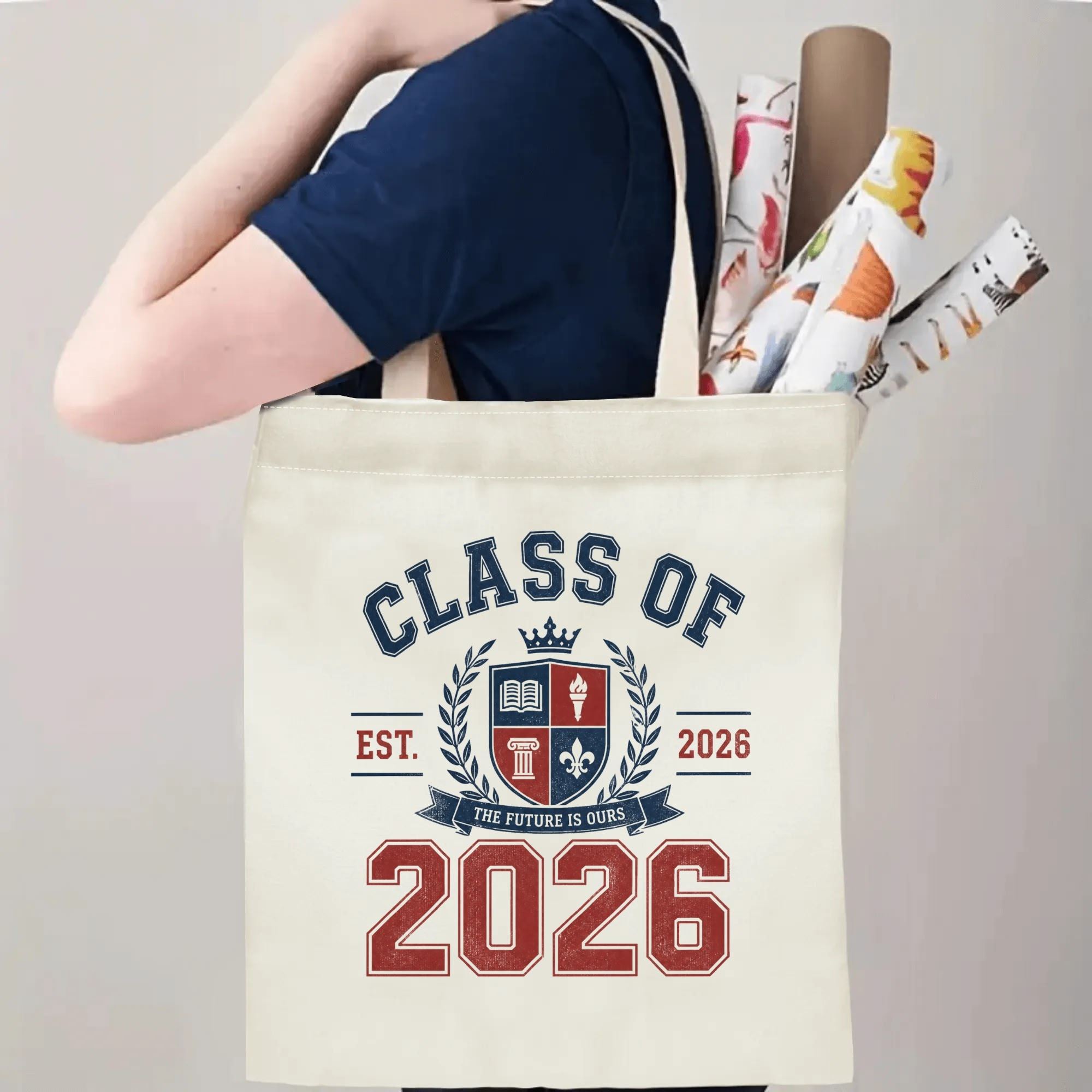 Person carrying a “Class of 2026” graduation tote bag over the shoulder, with rolled posters and graduation essentials.