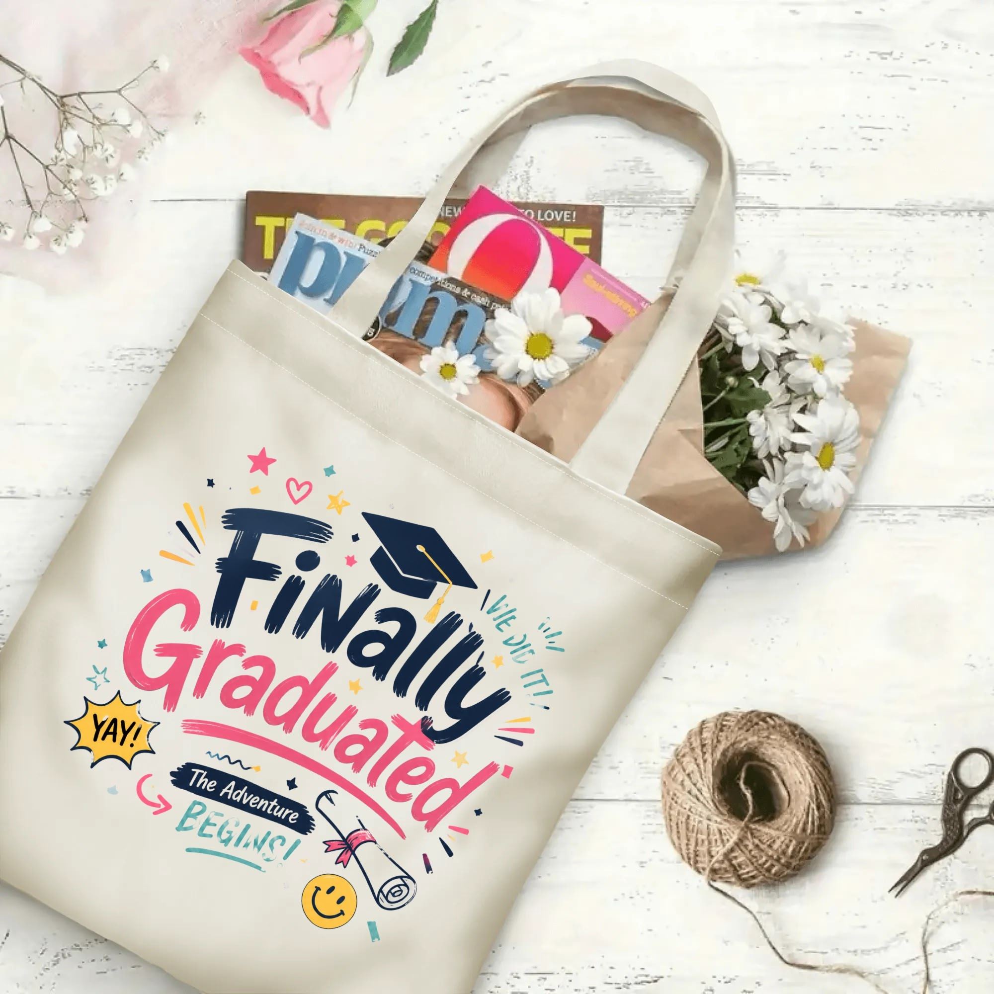 “Finally Graduated” cheerful-style canvas tote bag in use, holding books, flowers, and gifts.