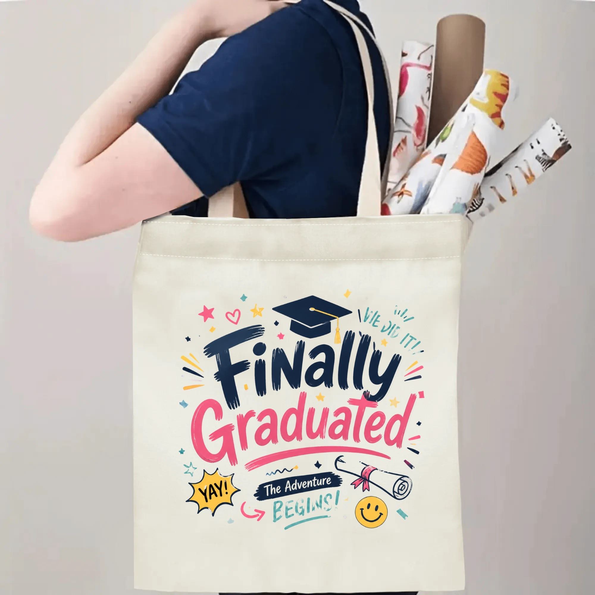 Person carrying a “Finally Graduated” graduation tote bag over the shoulder, with rolled posters and graduation essentials.