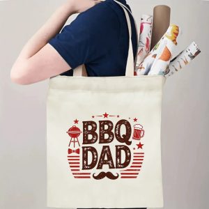 Person carrying a “BBQ Dad” Father’s Day tote bag over the shoulder, perfect for dad’s cookouts and outdoor outings.