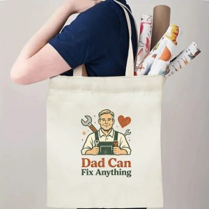 Person carrying a “Dad Can Fix Anything” Father’s Day tote bag over the shoulder, perfect for handy dads’ everyday errands and projects.