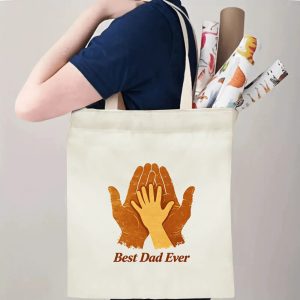 Person carrying a “Best Dad Ever” Father’s Day tote bag over the shoulder, perfect for celebrating the protective, loving bond between dad and child.