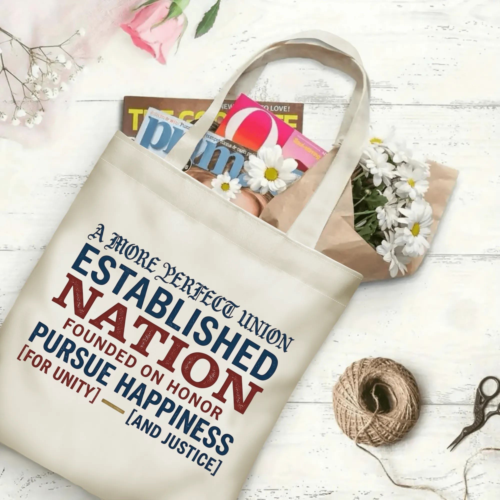 "A More Perfect Union" canvas tote bag filled with books and flowers, showcasing its spacious design for everyday use and patriotic events.