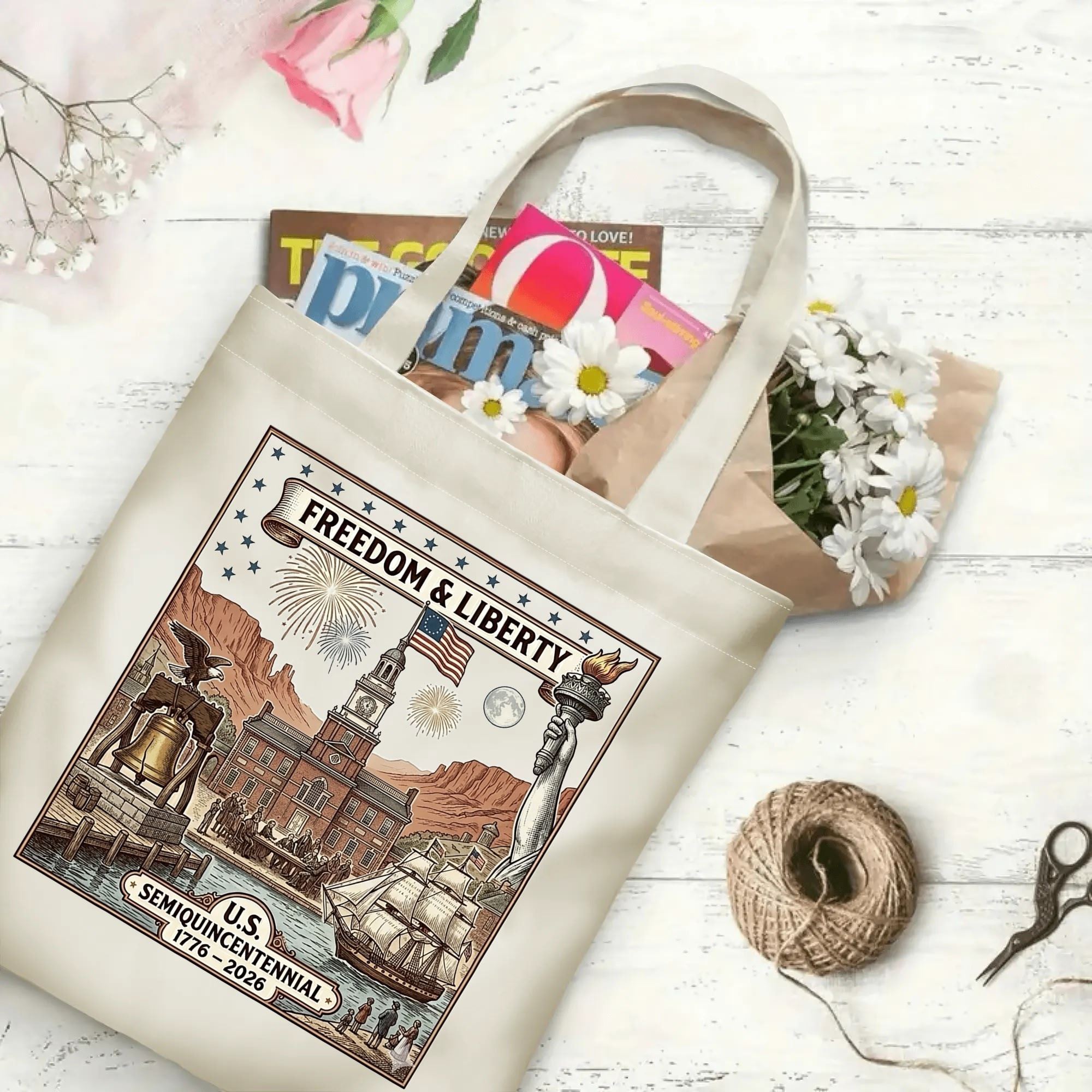 Retro patriotic scenic canvas tote laid flat on wooden desktop, stuffed with magazines and fresh daisies to display large daily storage capacity.