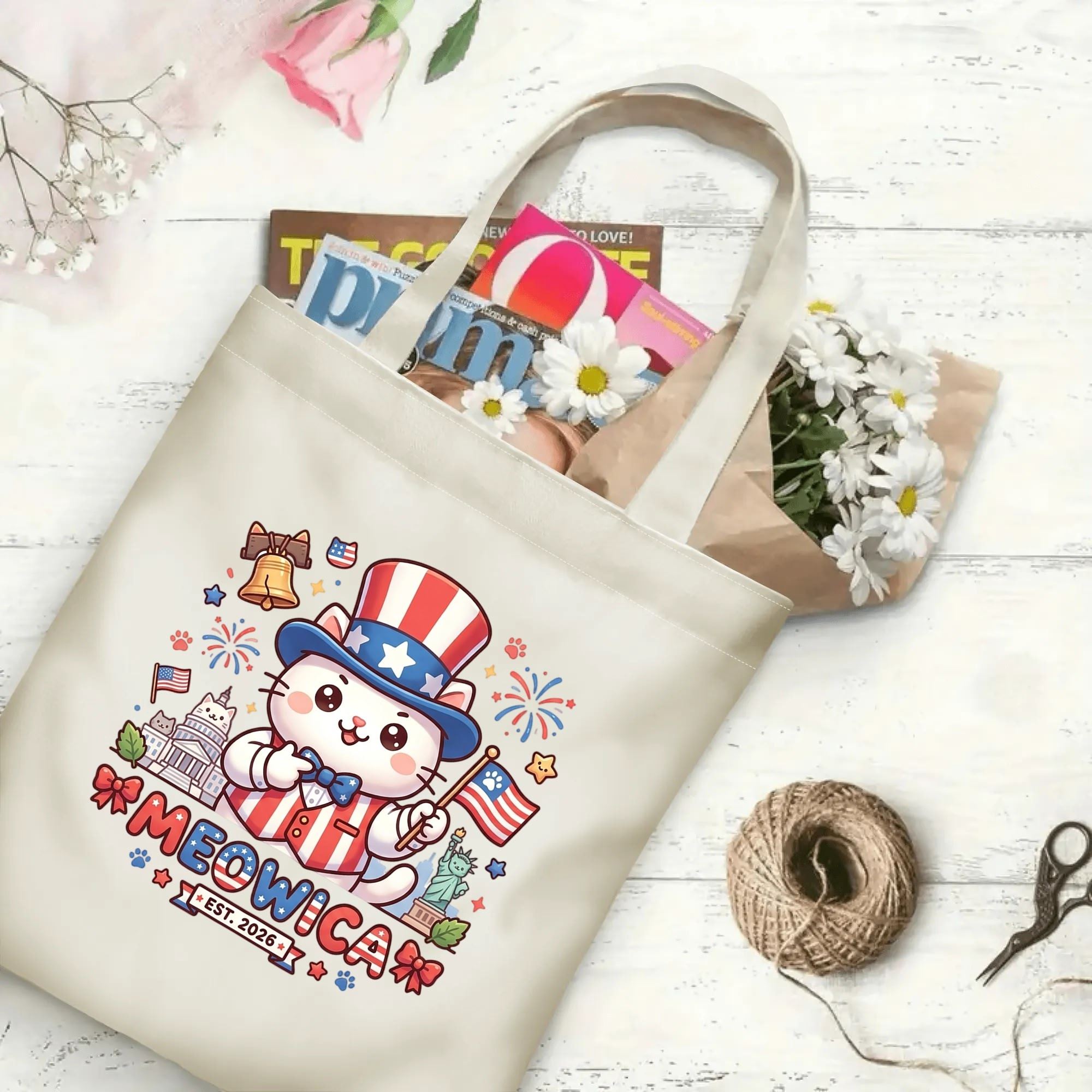 Kawaii Meowica cat patriotic canvas tote laid flat on wooden table, filled with magazines and fresh flowers to display daily storage capacity.
