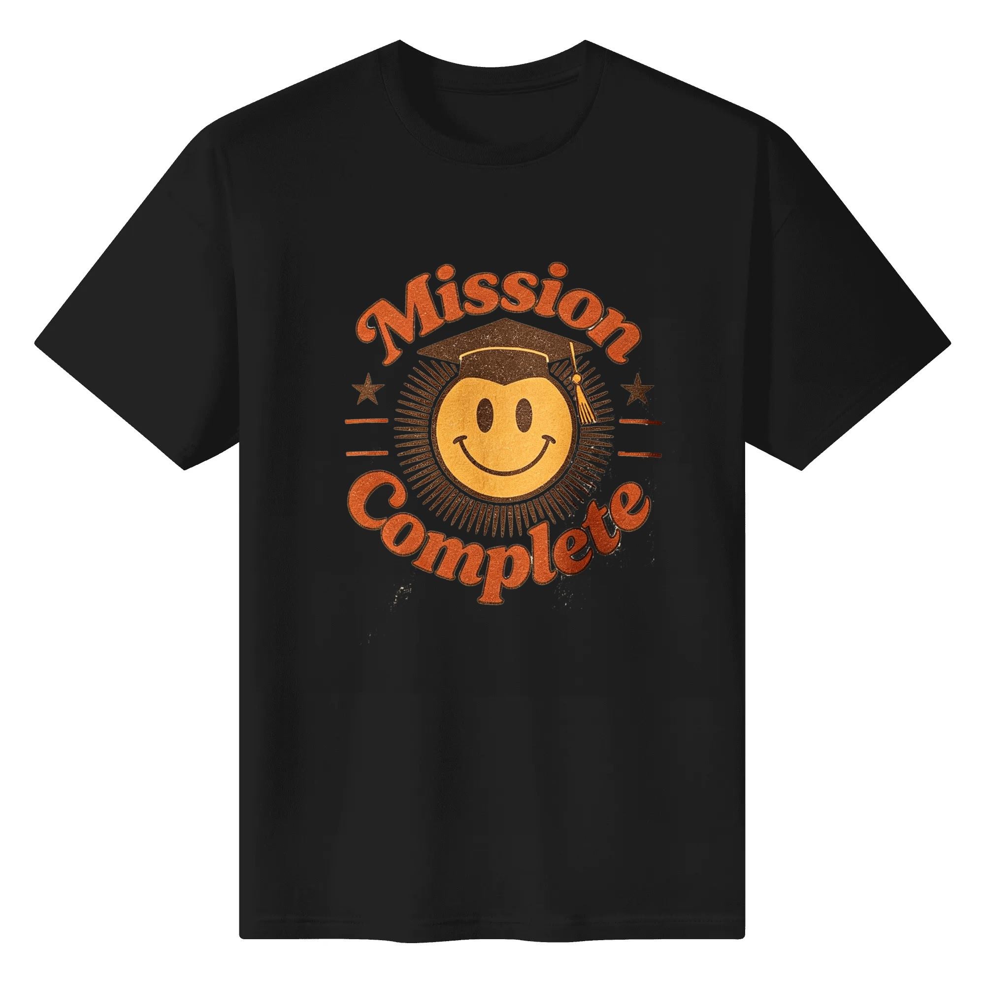 Black crewneck T-shirt with a retro “Mission Complete” graphic, featuring a smiley face in a graduation cap, distressed orange lettering, and star accents.