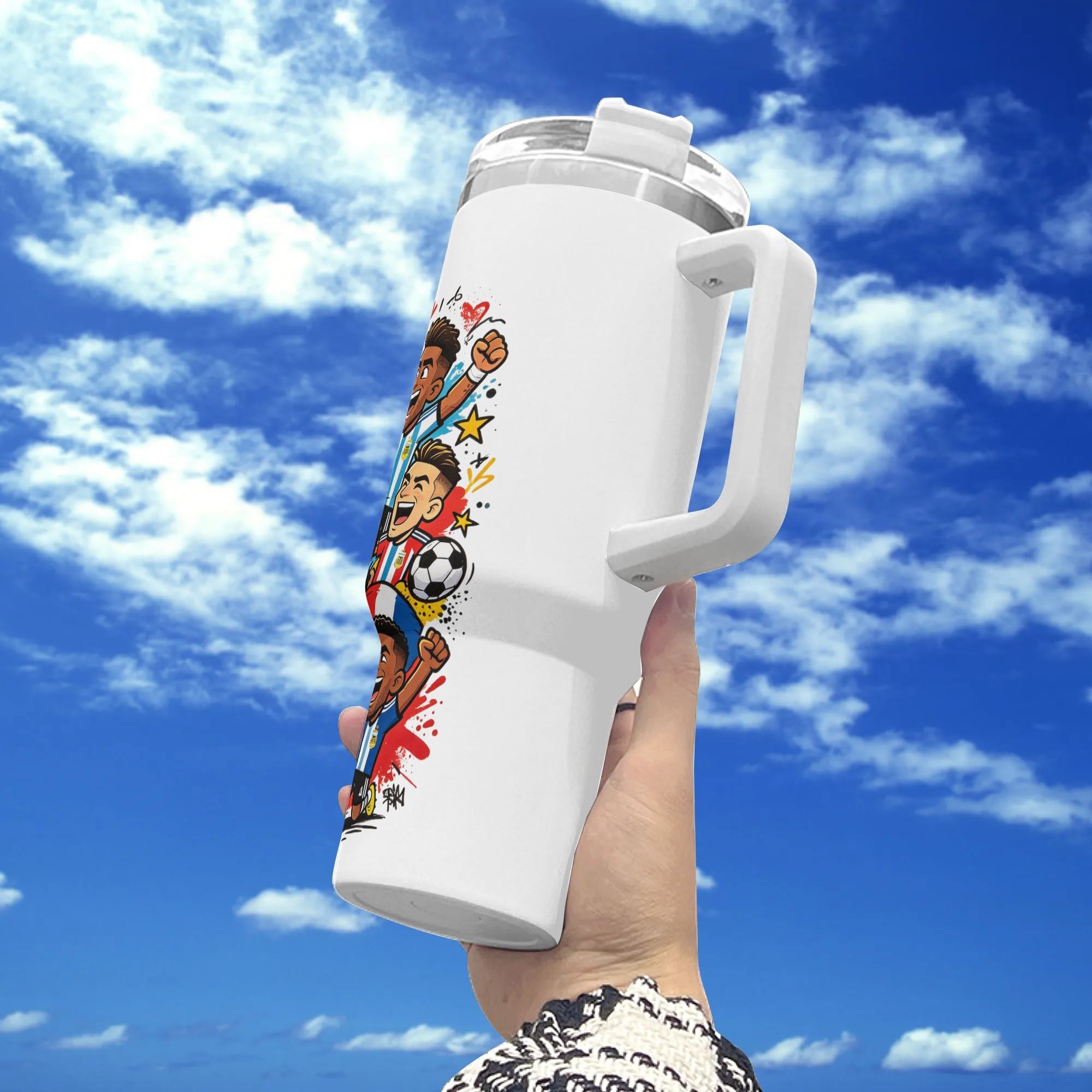White 40oz insulated stainless steel tumbler with handle, vibrant pop‑comic "Eat Sleep Soccer Repeat" national team soccer player splash print, held against blue sky background, energetic football fan travel mug